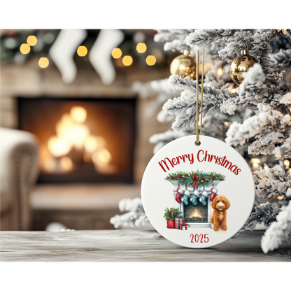 Christmas ornament with 'Merry Christmas' and a dog in front of a fireplace, placed on a table with a decorated tree and fireplace in the background.